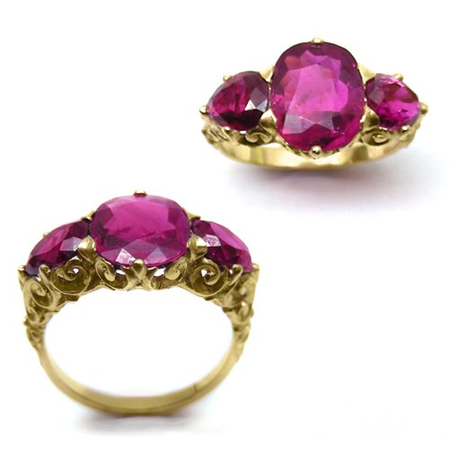 Three stone Burma ruby ring, the central oval cushion-cut ruby,